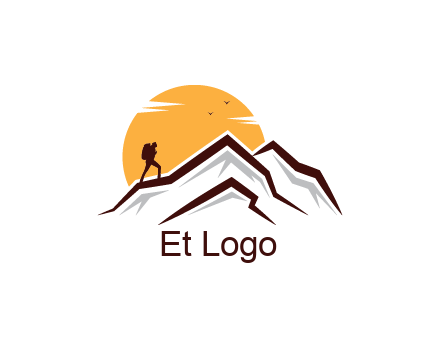 sun behind hiker on mountain